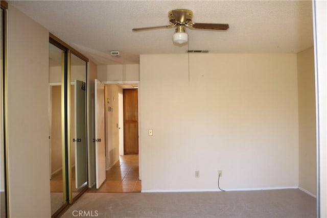 carpeted empty room with a textured ceiling and ceiling fan