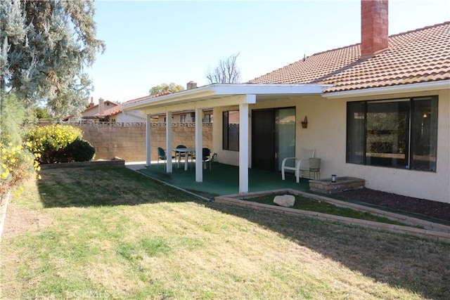 back of property with a patio area and a yard