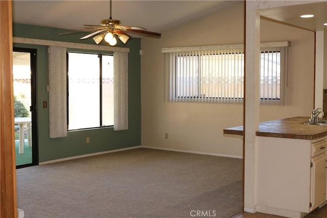 carpeted empty room with vaulted ceiling, ceiling fan, and sink