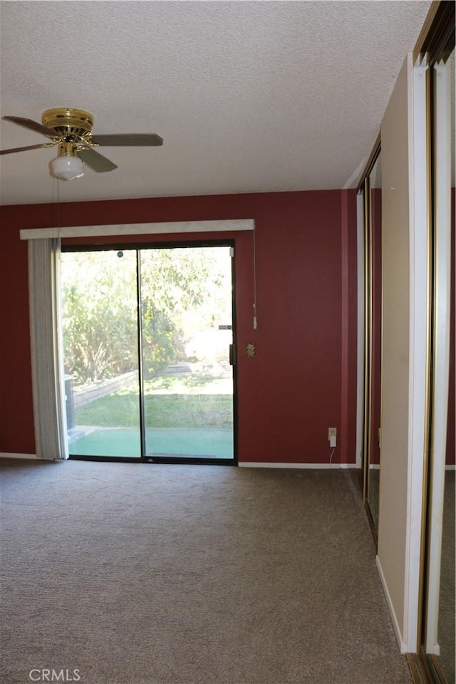 spare room featuring carpet, a textured ceiling, and ceiling fan