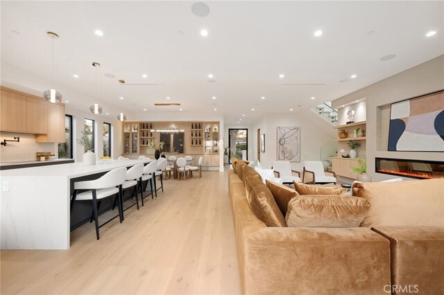 living room with built in features and light hardwood / wood-style floors