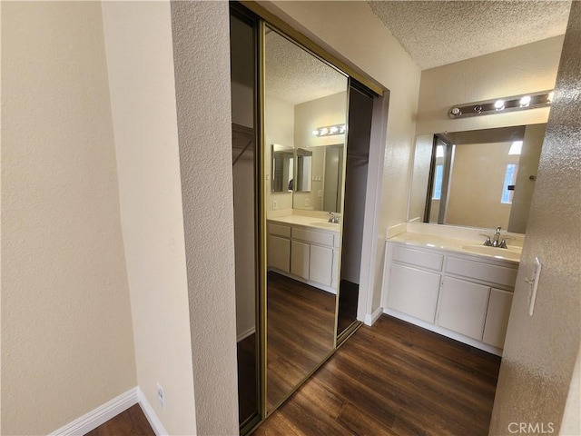 bathroom with a textured ceiling, vanity, and hardwood / wood-style floors