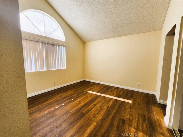 interior space featuring dark wood-type flooring, a textured ceiling, and vaulted ceiling