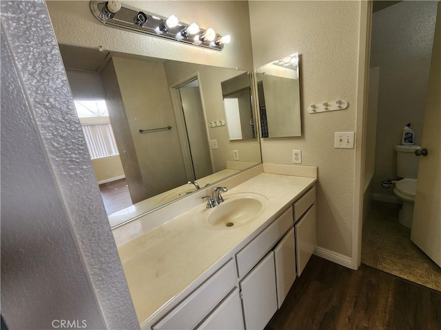 bathroom featuring hardwood / wood-style flooring, toilet, and vanity