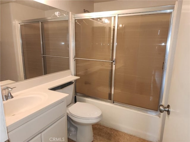 full bathroom with combined bath / shower with glass door, vanity, tile patterned flooring, and toilet