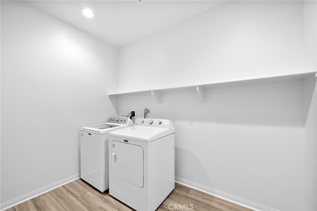 laundry room with laundry area, separate washer and dryer, baseboards, and wood tiled floor