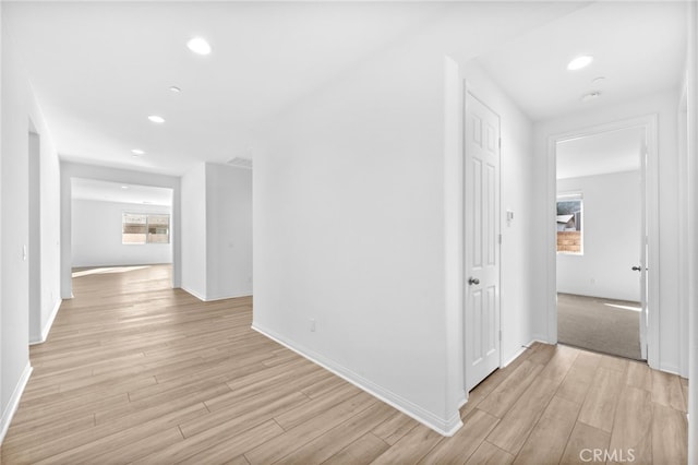 corridor with recessed lighting, light wood-style flooring, and baseboards