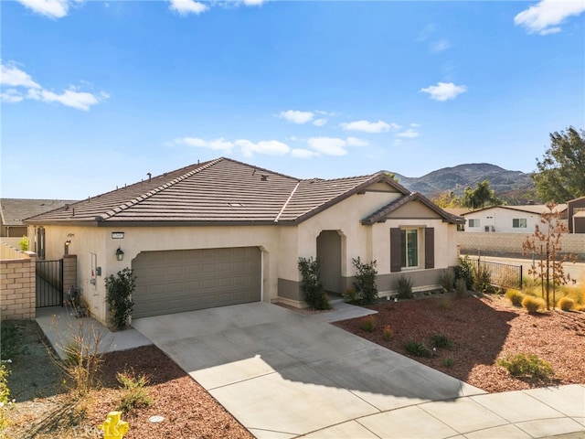 view of front of home featuring stucco siding, driveway, a gate, fence, and a garage