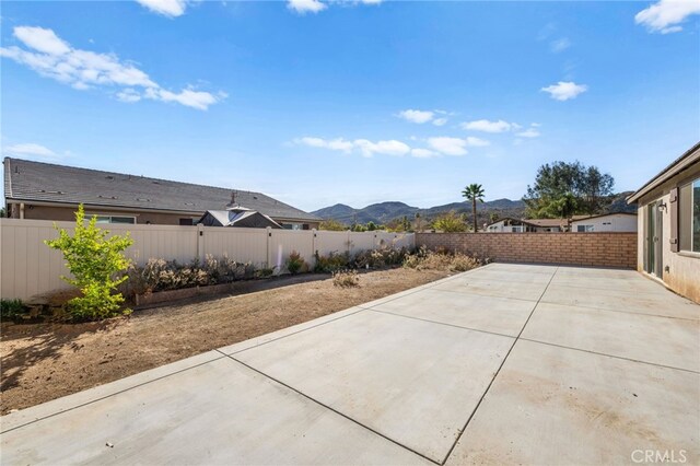 view of patio with a mountain view and a fenced backyard