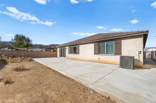 back of property with a patio, cooling unit, fence, and stucco siding