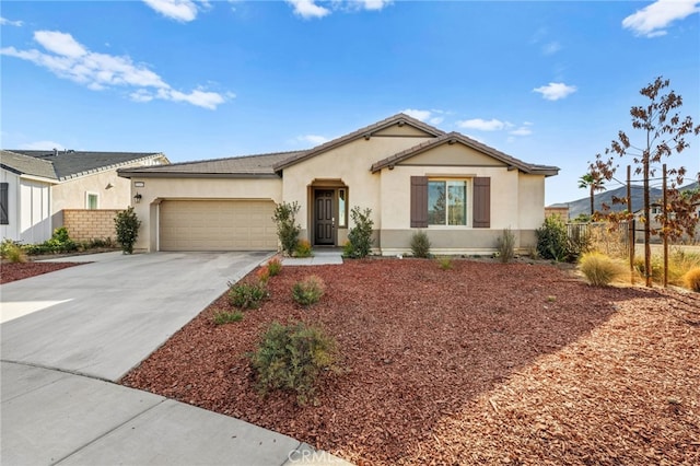 view of front of house featuring stucco siding, driveway, an attached garage, and fence