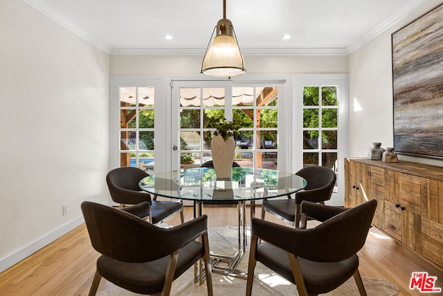 dining room featuring light wood-type flooring, french doors, and crown molding