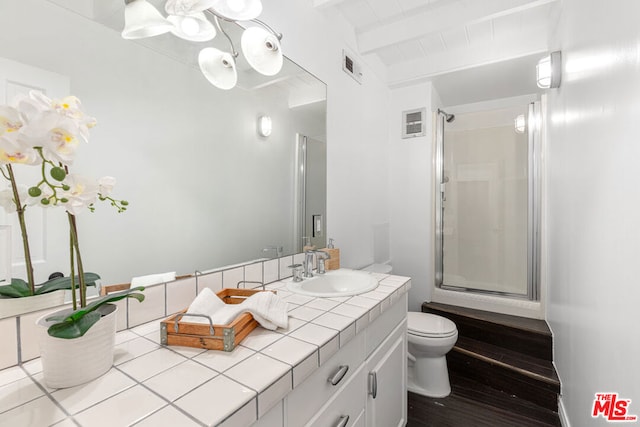 bathroom with beam ceiling, vanity, an enclosed shower, and toilet