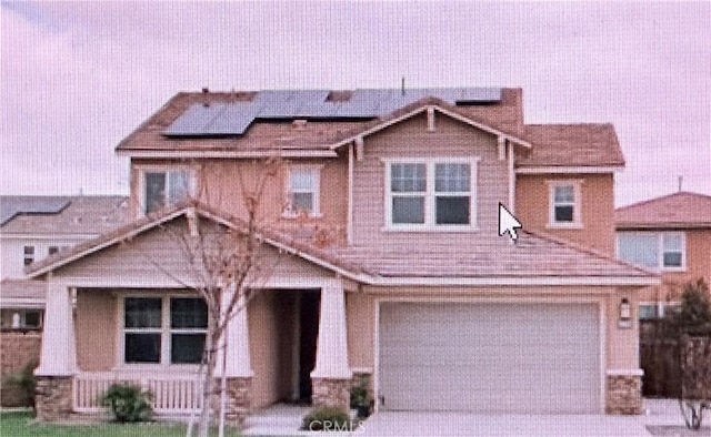 view of front of home featuring solar panels and a garage