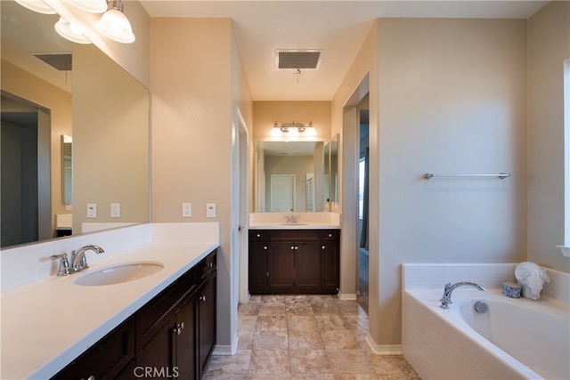 bathroom featuring visible vents, a sink, and a bath