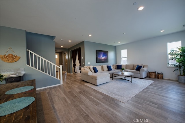 living room featuring recessed lighting, wood finished floors, and stairs