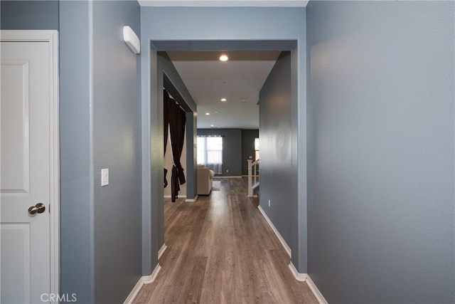 hallway featuring recessed lighting, baseboards, and wood finished floors