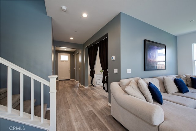 living area featuring recessed lighting, wood finished floors, and stairs