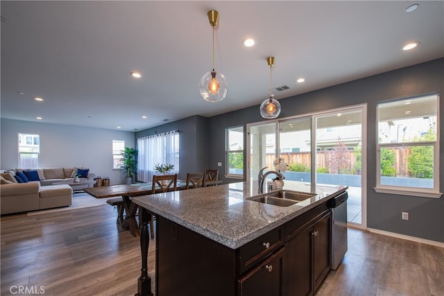 kitchen featuring stainless steel dishwasher, dark wood-type flooring, a sink, and dark brown cabinetry