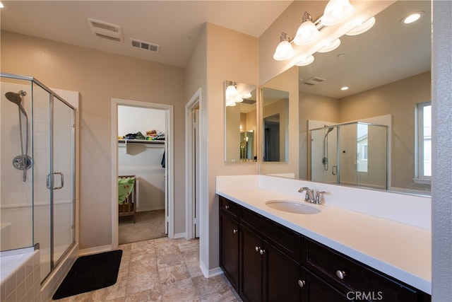 full bath featuring a stall shower, a walk in closet, and visible vents