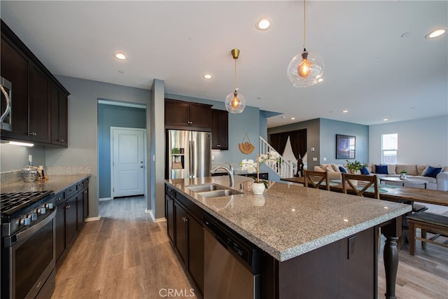 kitchen featuring stainless steel appliances, recessed lighting, a sink, and dark brown cabinetry