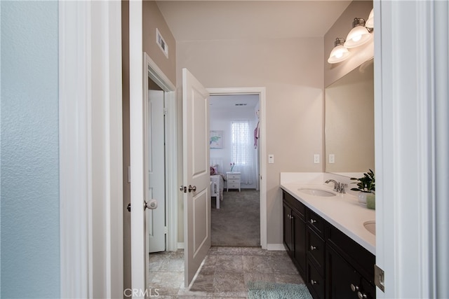 bathroom featuring double vanity, visible vents, a sink, and ensuite bathroom