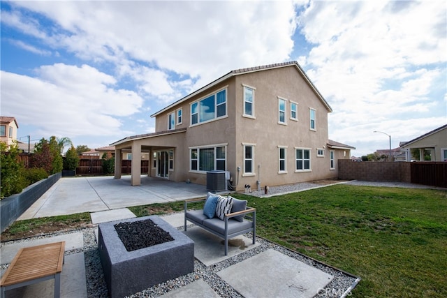 rear view of property with an outdoor living space with a fire pit, a fenced backyard, a yard, a patio area, and stucco siding