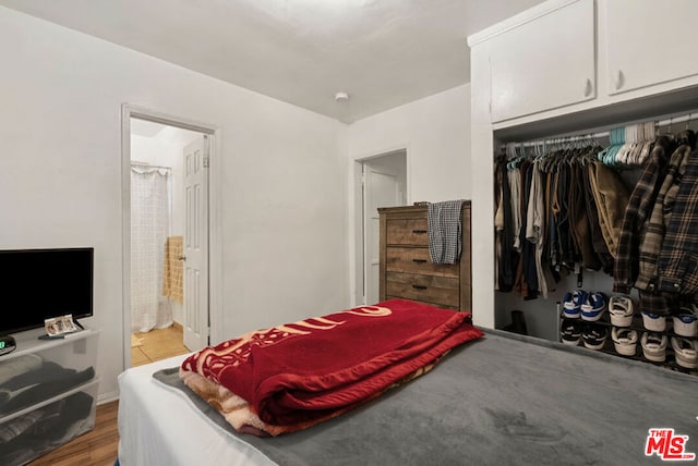 bedroom featuring light hardwood / wood-style floors, connected bathroom, and a closet