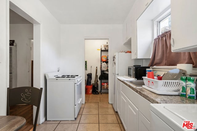 kitchen featuring white cabinets, light tile patterned floors, and white appliances