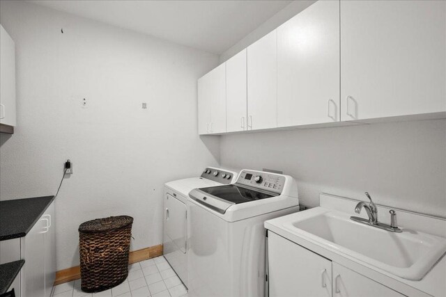 washroom with independent washer and dryer, cabinets, light tile patterned flooring, and sink