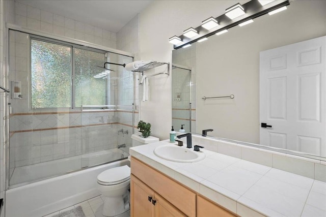 full bathroom with vanity, tile patterned floors, shower / bath combination with glass door, and toilet