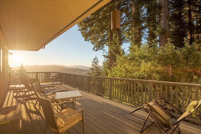 deck at dusk featuring a mountain view