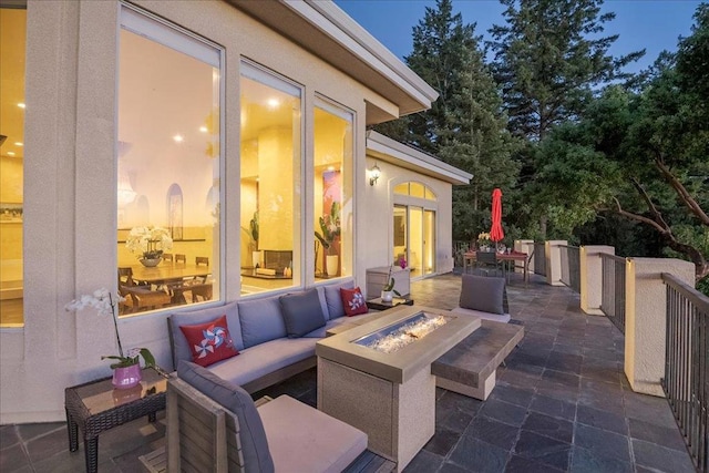 patio terrace at dusk featuring an outdoor living space with a fire pit