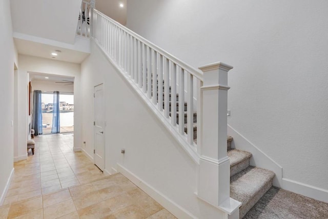 stairs with tile patterned floors and ceiling fan