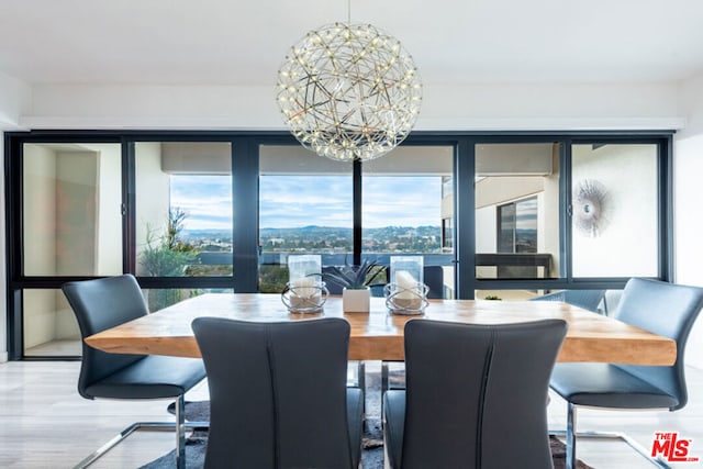 dining space with wood-type flooring and a notable chandelier