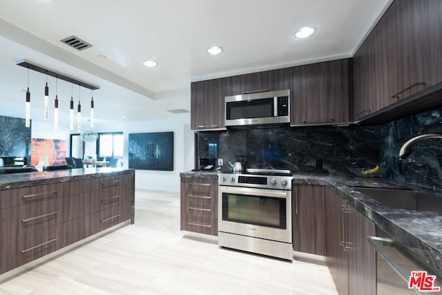 kitchen featuring dark brown cabinetry, appliances with stainless steel finishes, sink, and backsplash