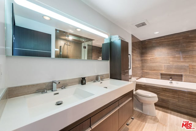 full bathroom featuring vanity, tiled shower / bath combo, and toilet