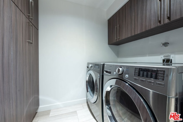 washroom with washer and clothes dryer and cabinets