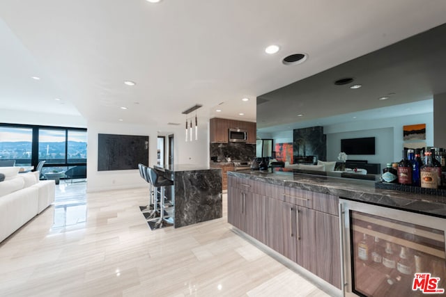 kitchen with hanging light fixtures, beverage cooler, and decorative backsplash