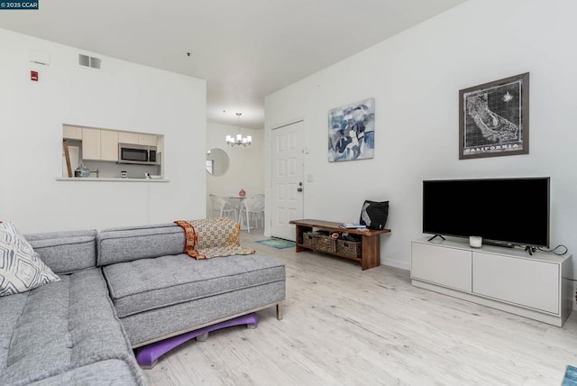 living room featuring light hardwood / wood-style flooring and a notable chandelier