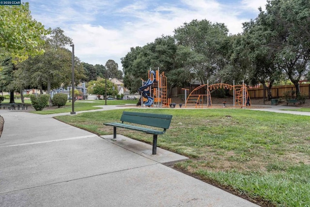 view of property's community featuring a playground and a lawn