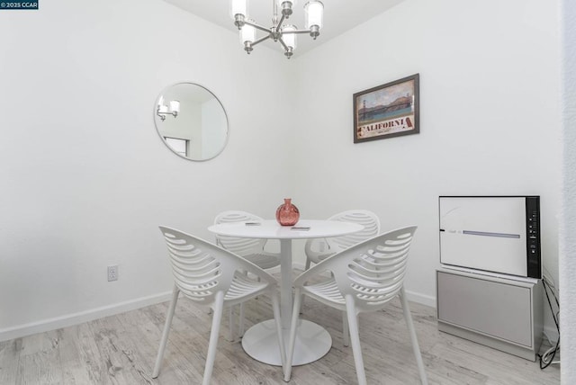 dining space featuring light hardwood / wood-style floors and a notable chandelier