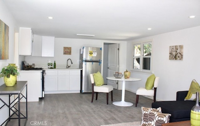 kitchen featuring sink, stainless steel refrigerator, white cabinetry, white electric range oven, and dark hardwood / wood-style flooring