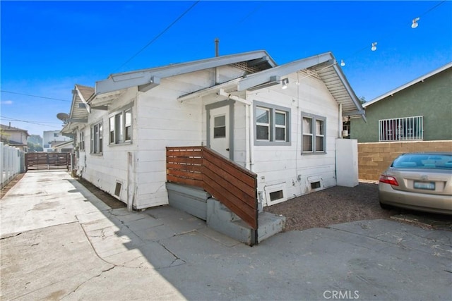 view of side of home with fence and crawl space
