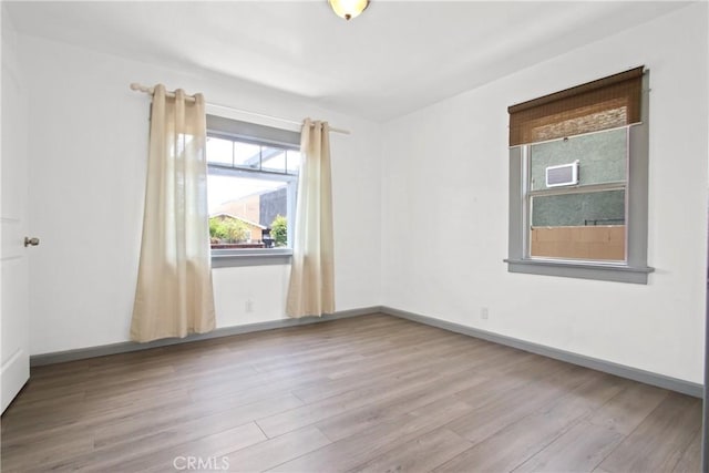spare room with wood finished floors and baseboards