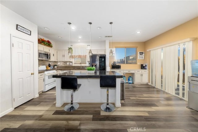 kitchen featuring stainless steel appliances, white cabinetry, and a center island