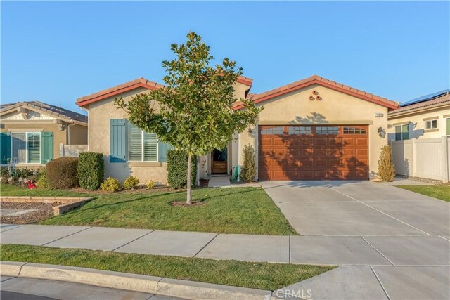 mediterranean / spanish house with a front lawn and a garage