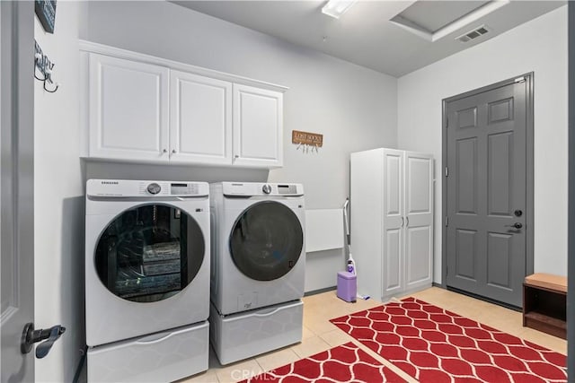 laundry area featuring cabinets, light tile patterned flooring, and washing machine and clothes dryer