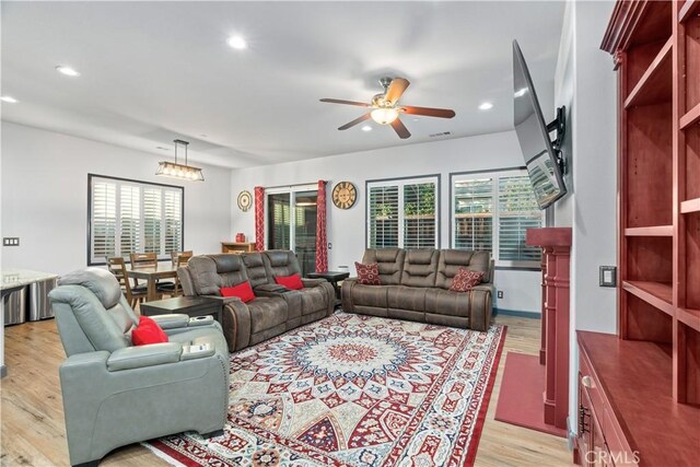 living room with ceiling fan, light hardwood / wood-style floors, and a healthy amount of sunlight