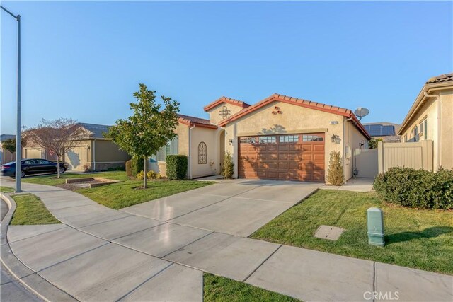 mediterranean / spanish-style home featuring a front lawn and a garage